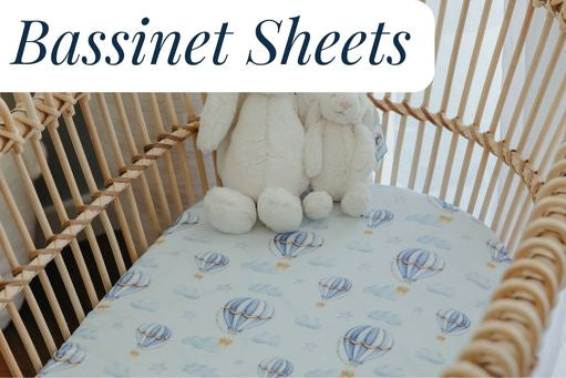 White Jellycat bunnies sitting in a bassinet