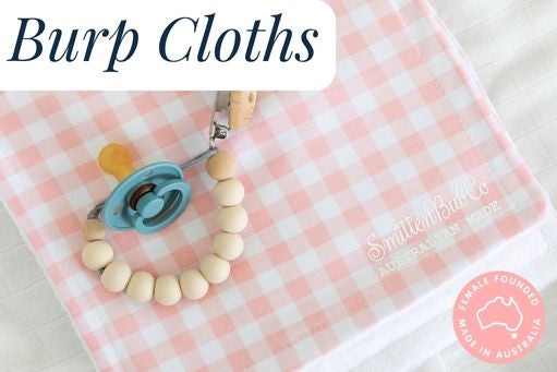 A baby dummy and chain placed on top of a burp cloth with a pink gingham patter