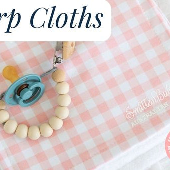 A baby dummy and chain placed on top of a burp cloth with a pink gingham patter