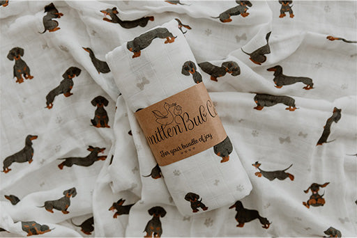Dachshund Bamboo Cotton Muslin Wrap. White background with Sausage Dog and paw print imagery.